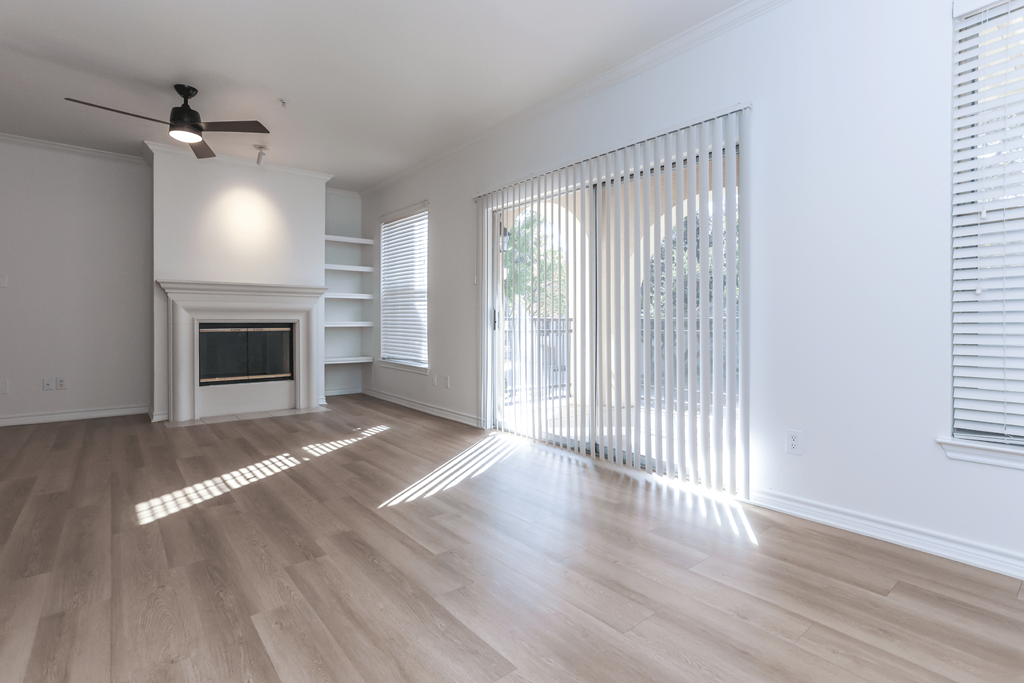 A spacious living room with a fireplace and sliding glass doors.